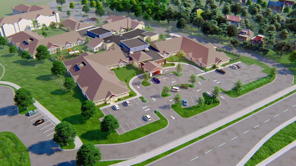 Aerial view of one-level healthcare facility surrounded by trees.