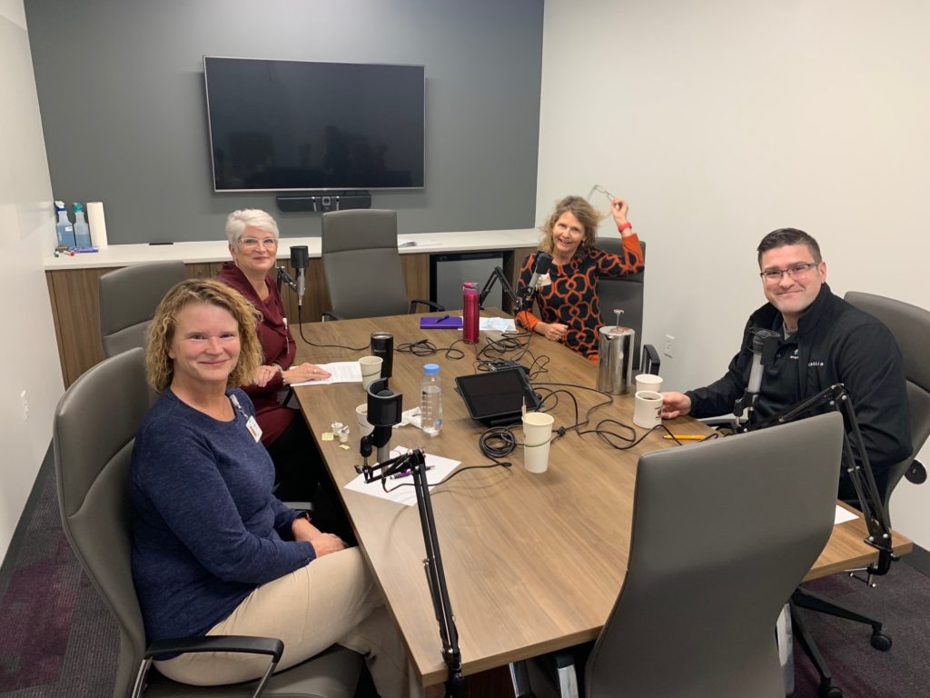 Jeri Rosenberg, LuAnn Gordon and Nate Cunningham chat with Nancy Carlson in a Cassia conference room.