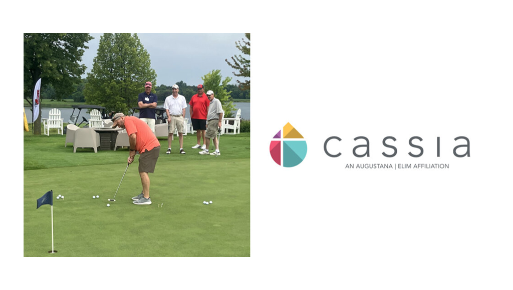 A golfer stands on the putting green getting ready to hit the ball.