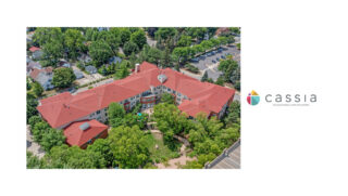 Aerial view of The Pines of Richfield, an 83-unit assisted living community with red roofs, surrounded by lush greenery and a quiet residential neighborhood.