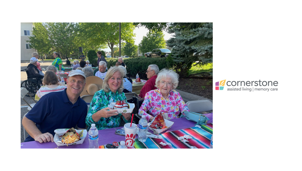 Three people sit together at a table enjoying refreshments at Cornerstone Assisted Living's 2024 Night to Unite.