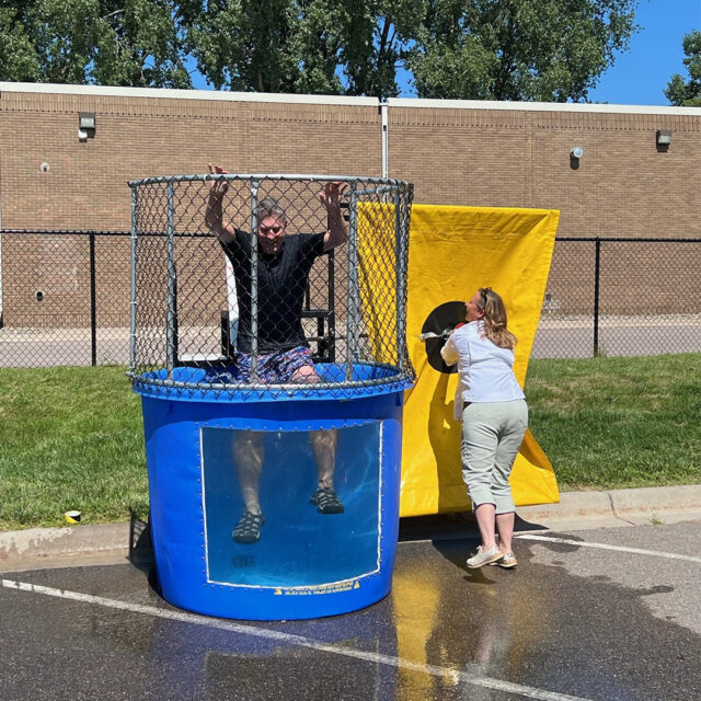 Cassia employee prepares to press the target, getting ready to dunk a colleague who is sitting in a dunk tank during a State Fair-inspired picnic event.