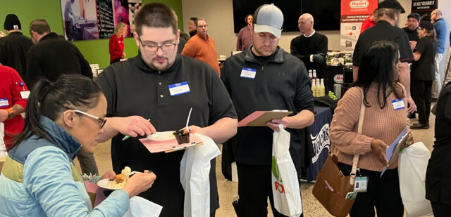 Cassia culinary team members taste and evaluate food samples during a US Foods food show.