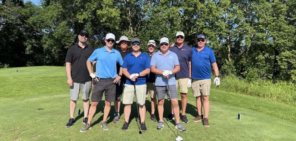 A group of golfers pose together on the course during the 25th annual Wright County Golf Tournament.