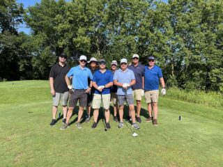A group of golfers pose together on the course during the 25th annual Wright County Golf Tournament.