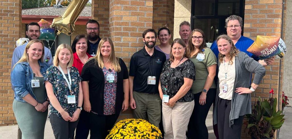 Lake Ridge Health Care Center staff in Buffalo, Minnesota, celebrate being ranked No. 1 in Minnesota Quality Measures for 2025, standing together outside the care center with balloons and flowers.
