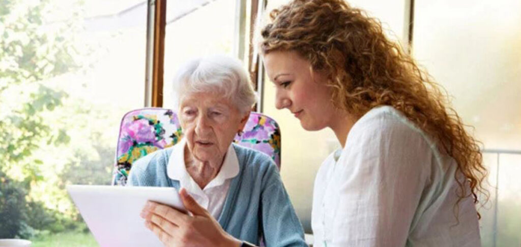A senior and adult child looking at a paper