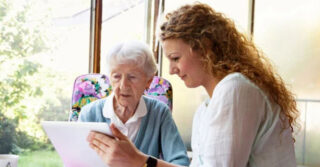 A senior and adult child looking at a paper