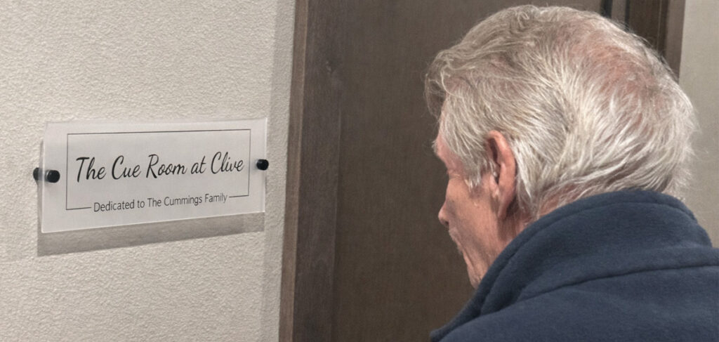 A resident looking at the cue room sign