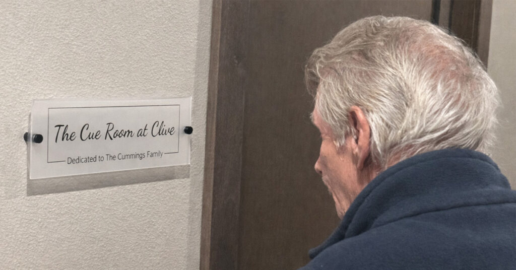 A resident looking at the cue room sign
