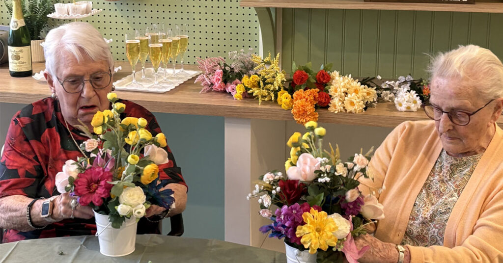 Residents take part in group floral activity in memory care programming at Trinity Springs promoting engagement and connection