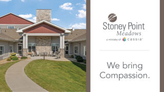 Exterior view of Stoney Point Meadows senior living community in Cedar Rapids, featuring landscaped grounds, walking path, and main entrance with seating area.