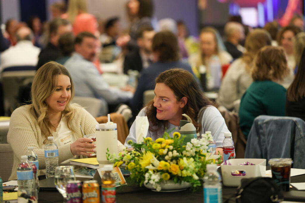 Cassia team members connect during a session at the 2026 Cassia Conference, seated at tables with notes, beverages, and floral centerpieces.