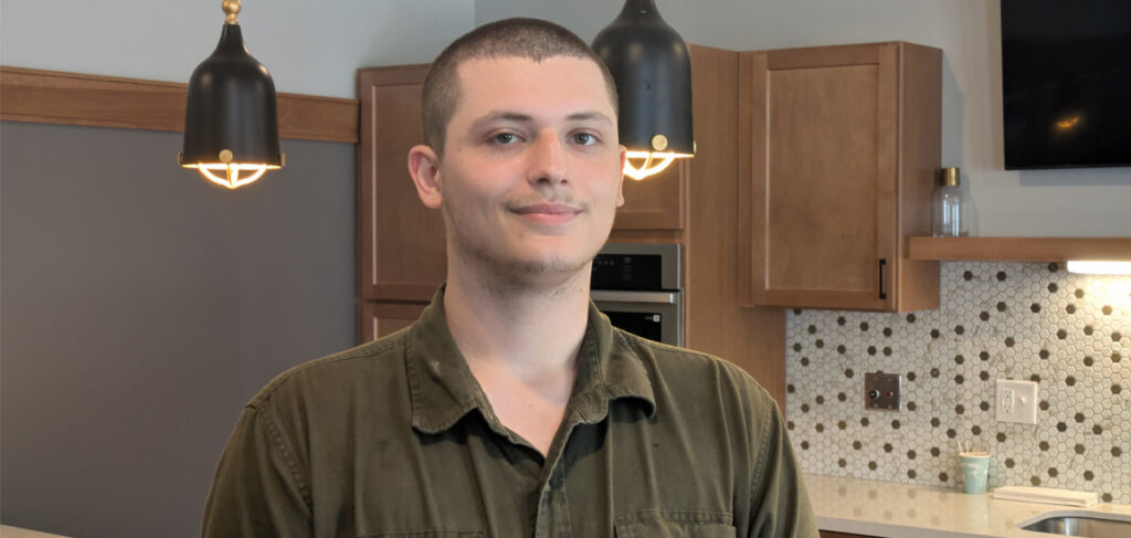 Chris, Culinary Director at Harmony Gardens, pictured in a bright community common area with cabinetry, countertops, and pendant lighting.