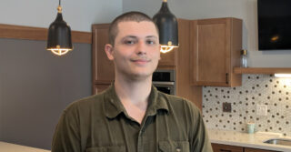 Chris, Culinary Director at Harmony Gardens, pictured in a bright community common area with cabinetry, countertops, and pendant lighting.