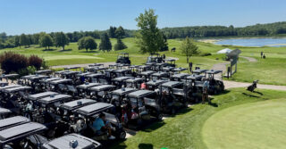 Rows of golf carts lined up at a golf course beside a lake during the Community Health Foundation of Wright County Golf Tournament in Buffalo, Minnesota.