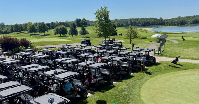 Rows of golf carts lined up at a golf course beside a lake during the Community Health Foundation of Wright County Golf Tournament in Buffalo, Minnesota.