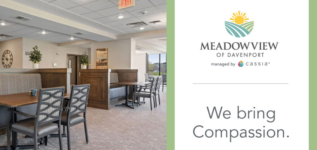 Meadowview of Davenport’s dining room features comfortable seating, wood accents, and large windows, alongside the community logo and the message, “We bring Compassion.”