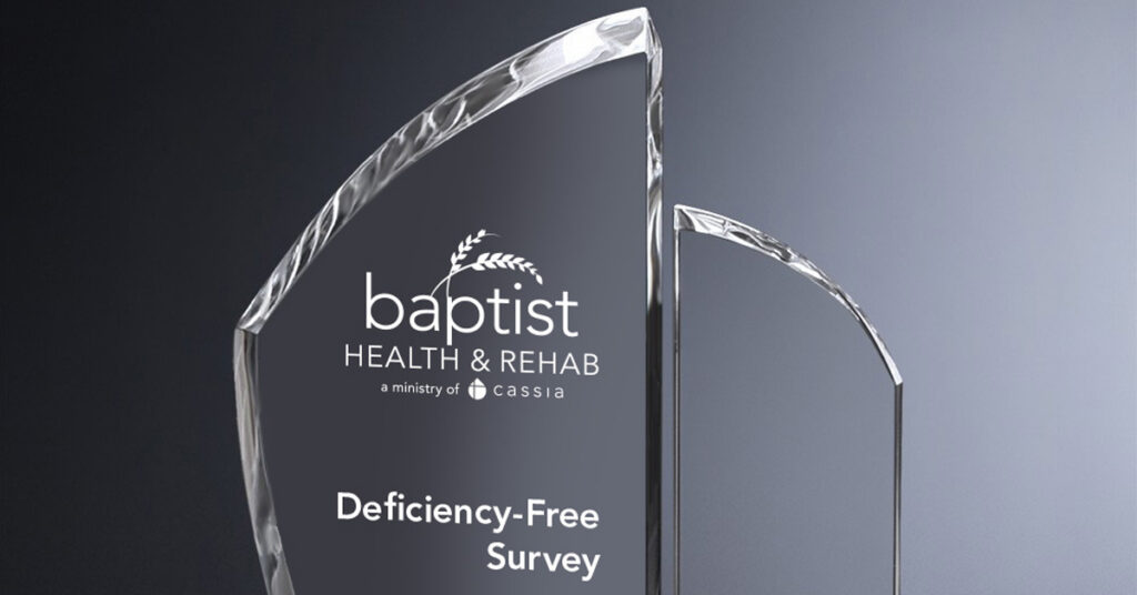 Crystal award engraved with “Baptist Health & Rehab” and “Deficiency-Free Survey” against a gray gradient background.